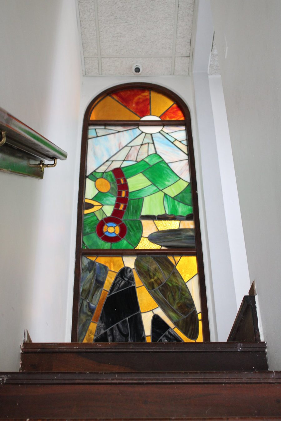 Vitral con el sol y las montañas en la escalera del bufete